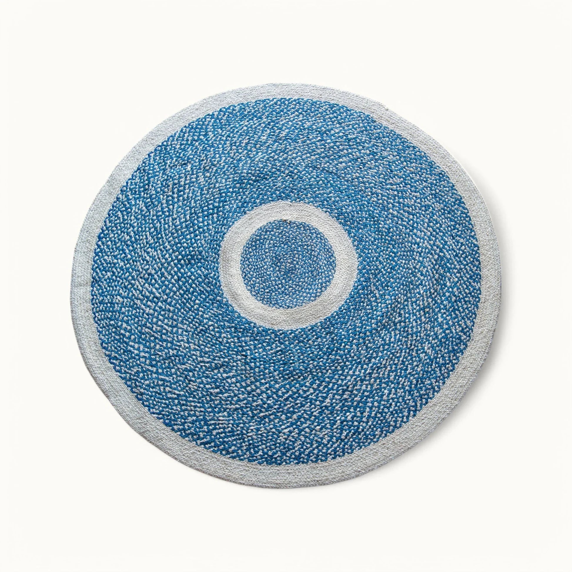 Handwoven round sisal rug marine blue variant with cream circle ring motif and light grey border on white background