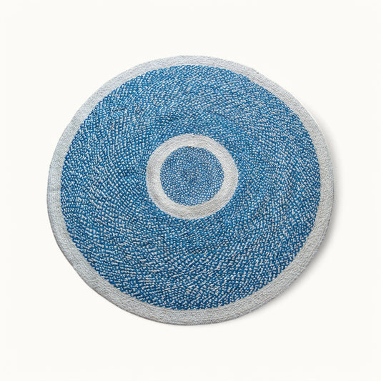 Handwoven round sisal rug marine blue variant with cream circle ring motif and light grey border on white background