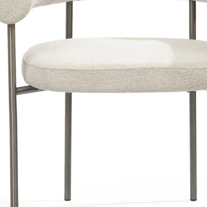 Close up of premium light gray boucle fabric upholstery on a modern dining chair with foam cushioning.