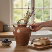 Vintage Poterie Renault Bonny sur Loire French Ceramic Pitcher in a rustic kitchen, with a woman's hand, bread & plums.