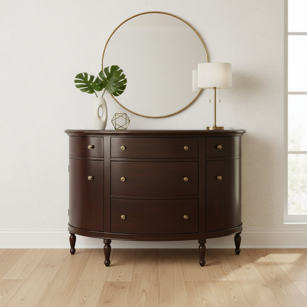 Lifestyle view of the Mahogany Demilune Console Chest styled with a round gold mirror and modern lamp on light wood floors.