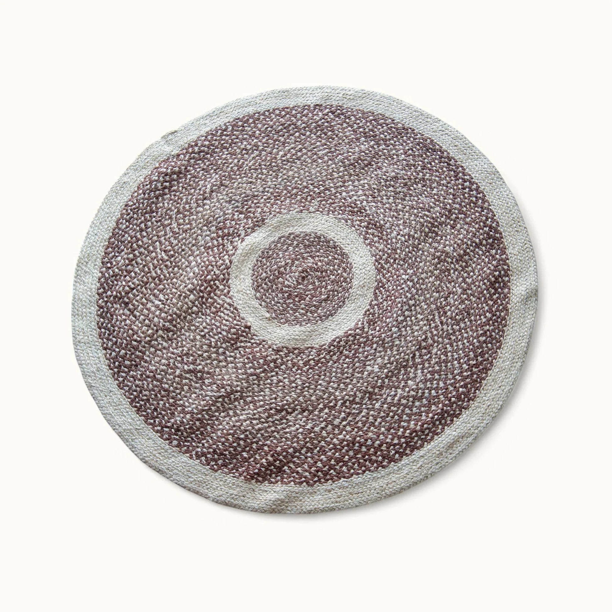 Handwoven medium round sisal rug red earth variant with red earth braided field cream circle ring motif and white border on white background