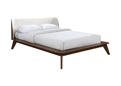 Mid-century walnut platform bed with beige boucle headboard and tapered legs on white background