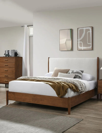 Mid-century full bed with warm walnut frame styled in a modern bedroom layout featuring textured gold throw blanket, decorative pillows, and minimalist wall art