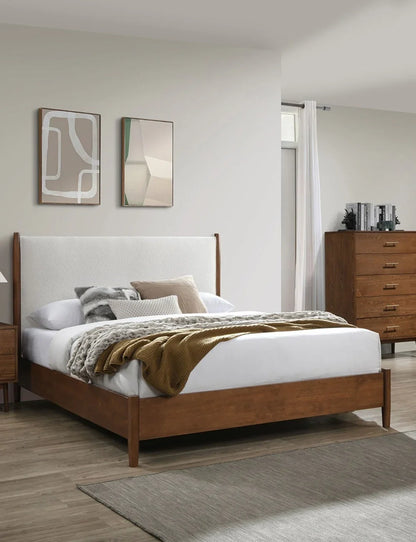 Full-size mid-century bed frame in a sunlit bedroom setting, flanked by matching walnut furniture, a neutral area rug, and contemporary abstract art prints