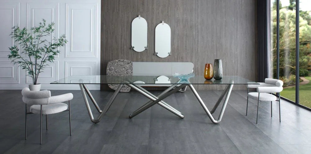 Pair of light gray boucle dining arm chairs styled in a contemporary luxury dining room with glass table.