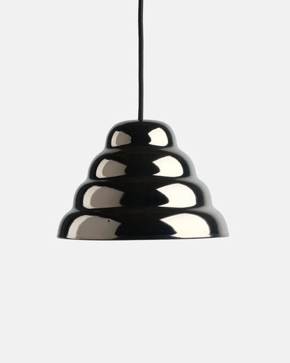 Modern ceramic pendant light showcasing a reflective metallic chrome glaze finish over a textured stepped ripple stoneware shade design against a plain studio background