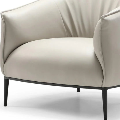 High-angle view of the light gray faux leather arm chair styled in a modern industrial loft with black steel accents.