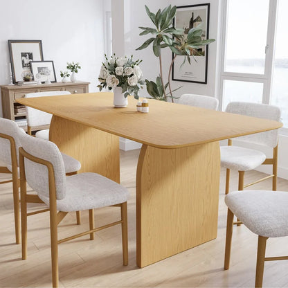 Premium sixty-six inch natural solid oak double pedestal dining table set with modern upholstered chairs and floral centerpiece in a bright contemporary dining room layout