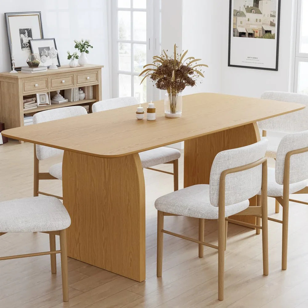 Premium sixty-six inch natural solid oak double pedestal dining table styled with six contemporary upholstered chairs in a bright minimalist room setting
