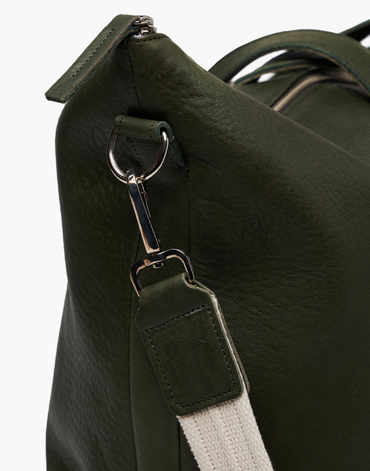 Close-up of the Malbec weekender in Green, showing the metal shoulder-strap clip, attachment ring, and stitched leather trim.