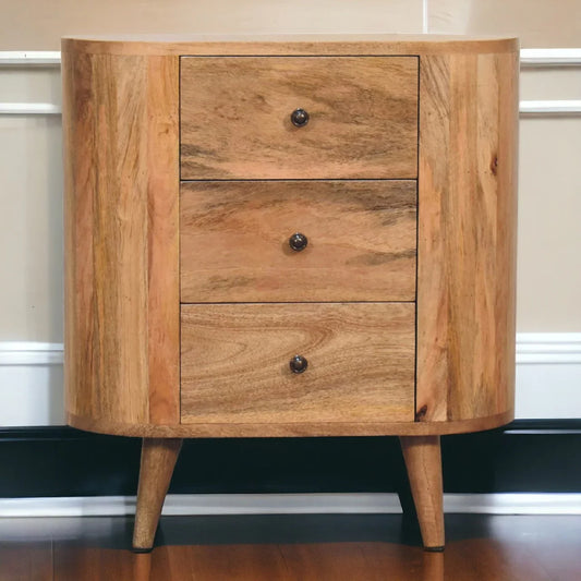 Oak-ish solid wood mini cabinet styled in bedroom setting with three drawers and Nordic splayed legs on hardwood floor