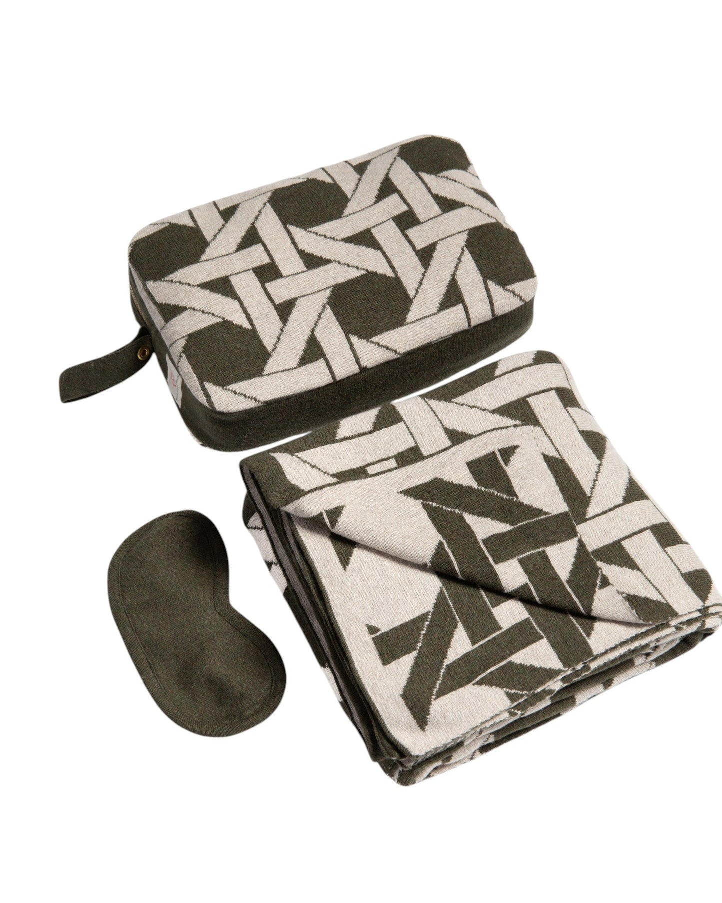 Olive green organic cotton travel blanket set with geometric pattern including compact pouch folded blanket and eye mask angled flat lay