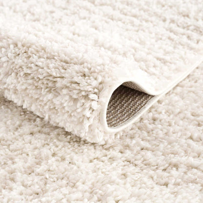 Plush Beige Shag Rug Rolled Corner Close-Up Showing Deep Pile Texture and Woven Backing | Fluent Trends