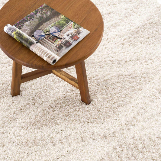 Plush Beige Shag Rug Styled with Round Wooden Stool and Magazine in Neutral Living Space | Fluent Trends