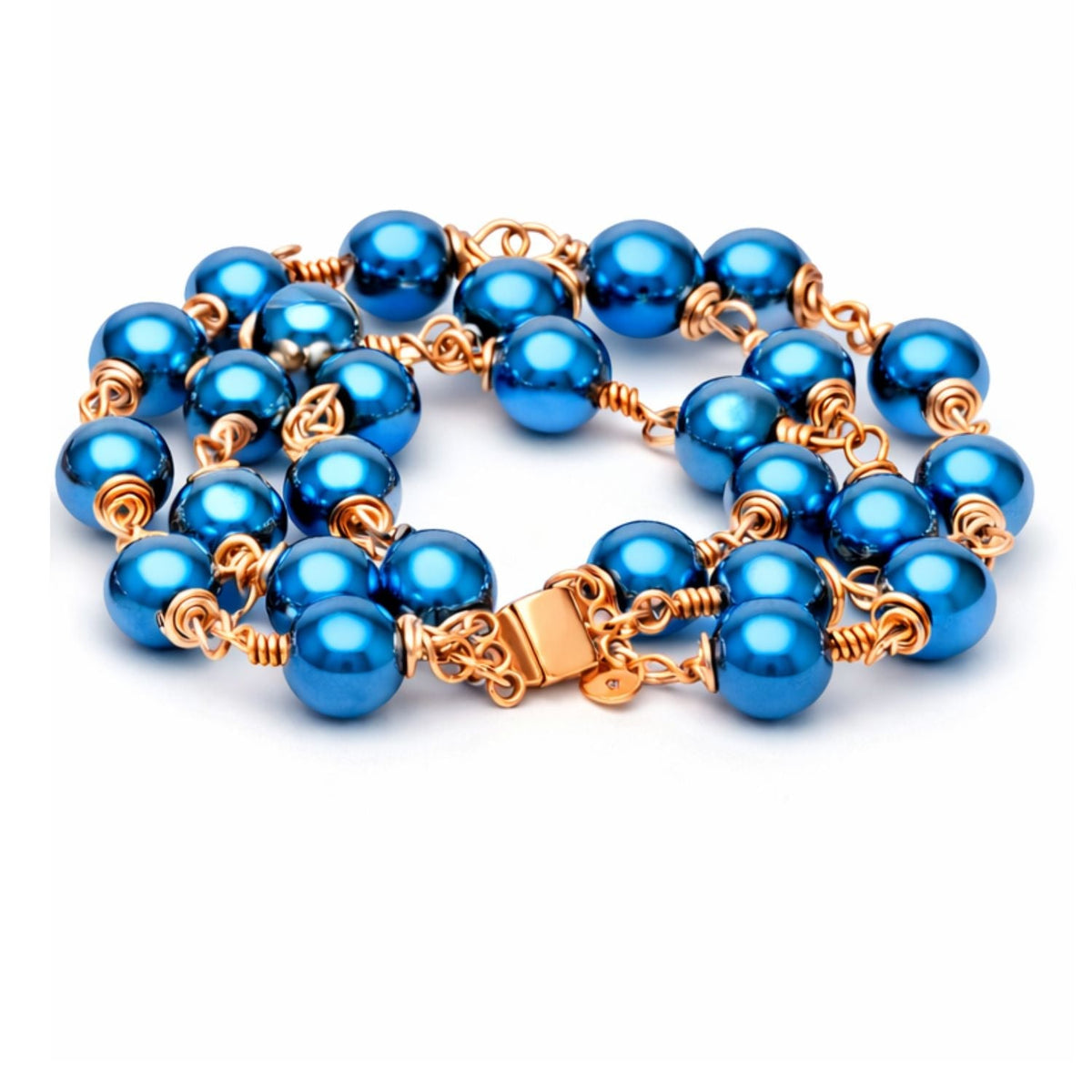 Celeste blue hematite artisan bracelet with three strands of shimmering blue beads, rose-gold-tone wire wrapping, and a flat magnetic clasp on a white background.