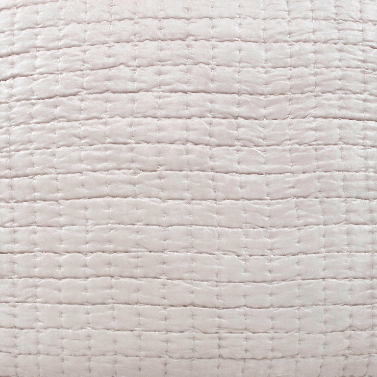 Close-up of the Malibu silk pillow sham showing square pick-stitch quilting, softly puckered fabric, and a subtle sheen in a pale warm-neutral tone.