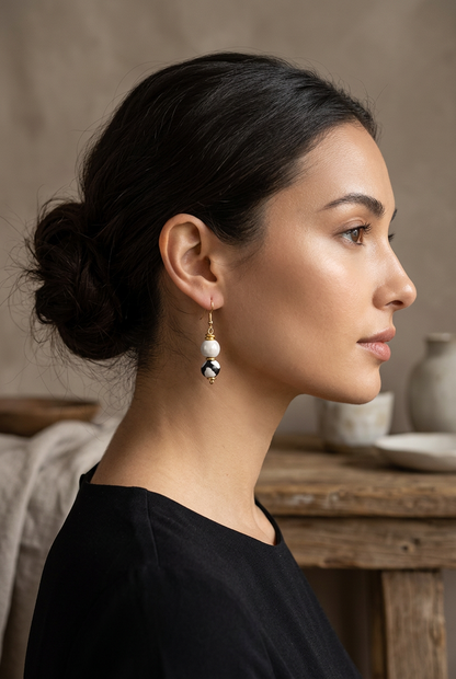 Profile view of a model wearing a Sefone drop earring with a cream upper bead, black-and-white patterned lower bead, and gold-tone accents.
