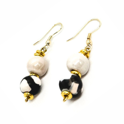Sefone artisan earrings with cream upper beads, black-and-white patterned clay beads, gold-tone accents, and curved hooks on a white background.