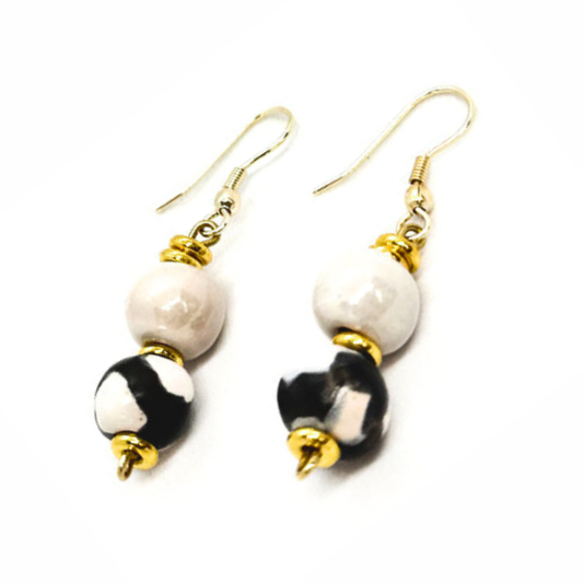 Sefone artisan earrings with cream upper beads, black-and-white patterned clay beads, gold-tone accents, and curved hooks on a white background.