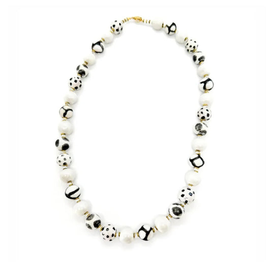 Sefone artisan necklace with cream clay beads, spotted and abstract black-and-white patterns, and small gold-tone accents on a white background.