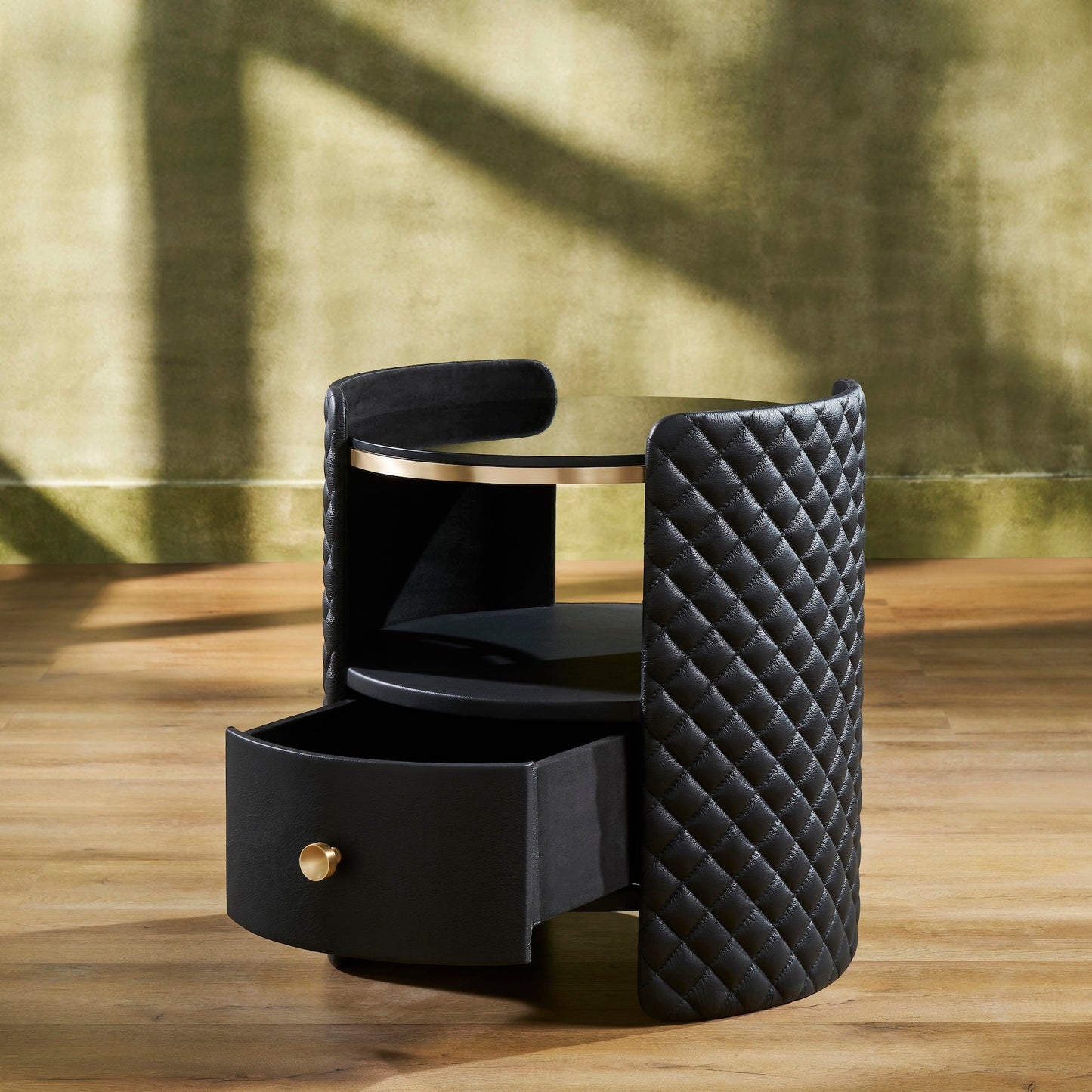 Quilted Round Leather Nightstand black angled view open drawer brass pull diamond quilting natural light