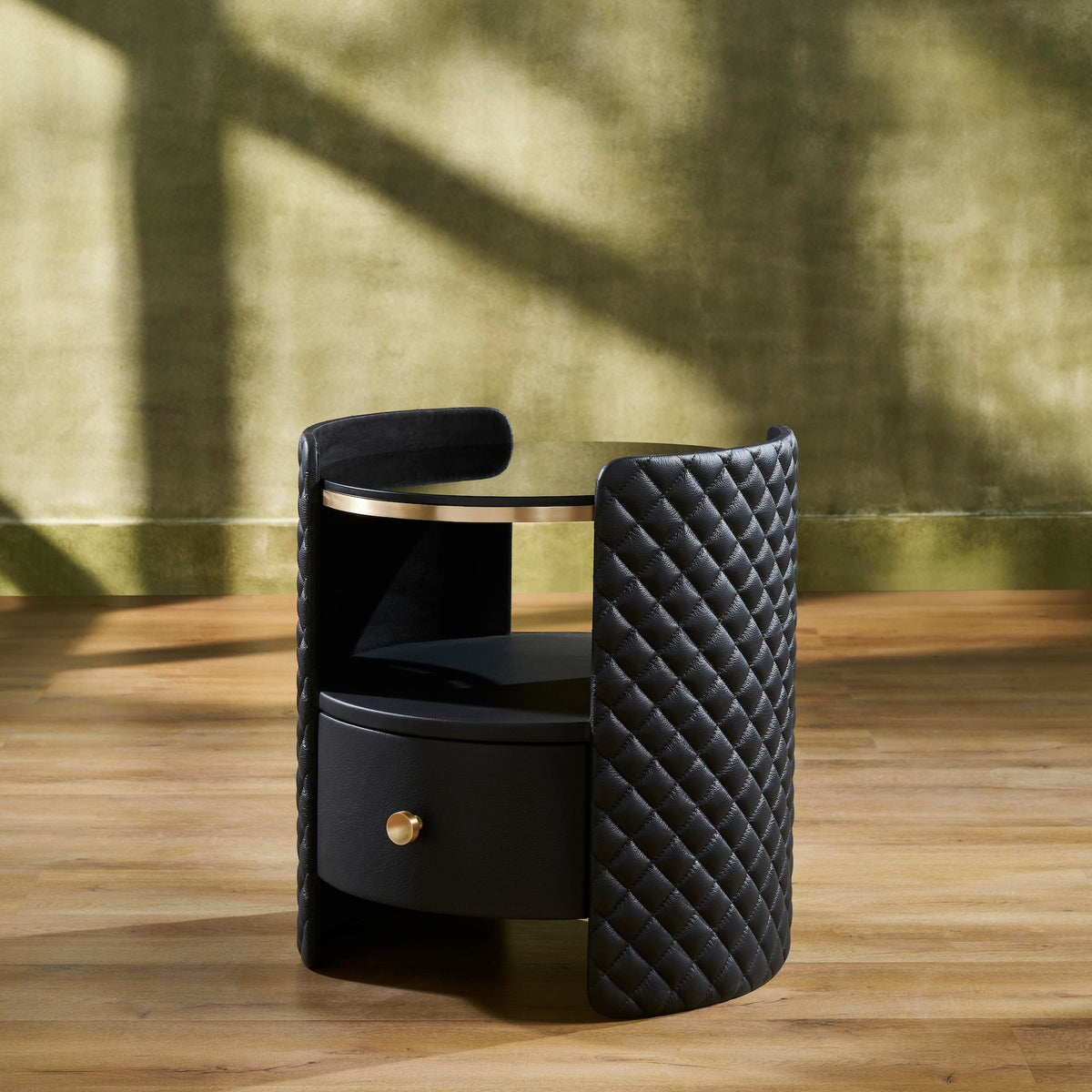 Quilted Round Leather Nightstand black three quarter view diamond quilting brass rim drawer closed natural light