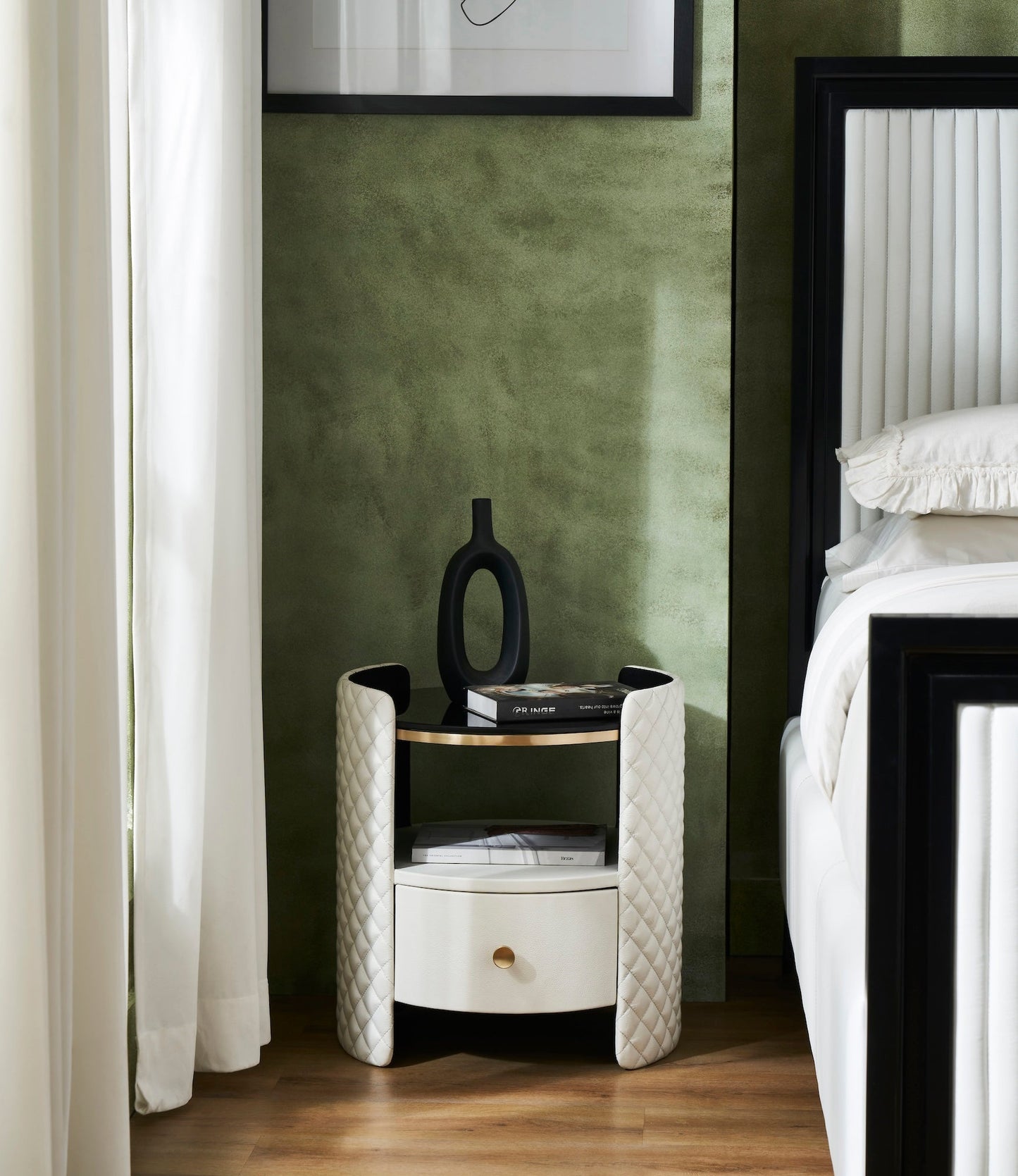 Quilted Round Leather Nightstand white bedroom lifestyle brass rim diamond quilting beside bed green wall 
