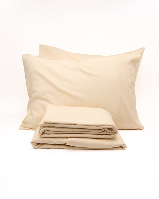 Signature Milk Fibre Core Set Cream two pillowcases and folded sheets on a white background