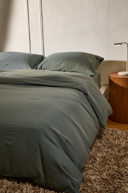Signature Milk Fibre Deluxe Set in Highlands Green with duvet cover and pillowcases on a styled bedroom bed