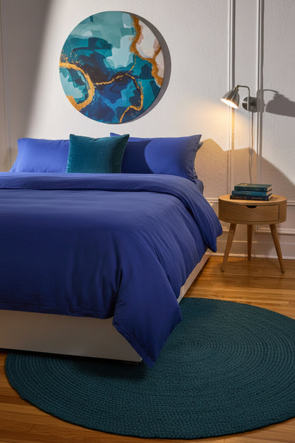 Signature Milk Fibre Deluxe Set Lunar Blue duvet cover and pillowcases on a styled bed with round abstract wall art and wood nightstand