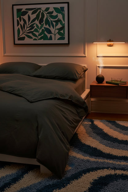 Signature Milk Fibre Duvet Cover Highlands Green on a bed in a warmly lit evening bedroom with botanical leaf wall art and striped area rug