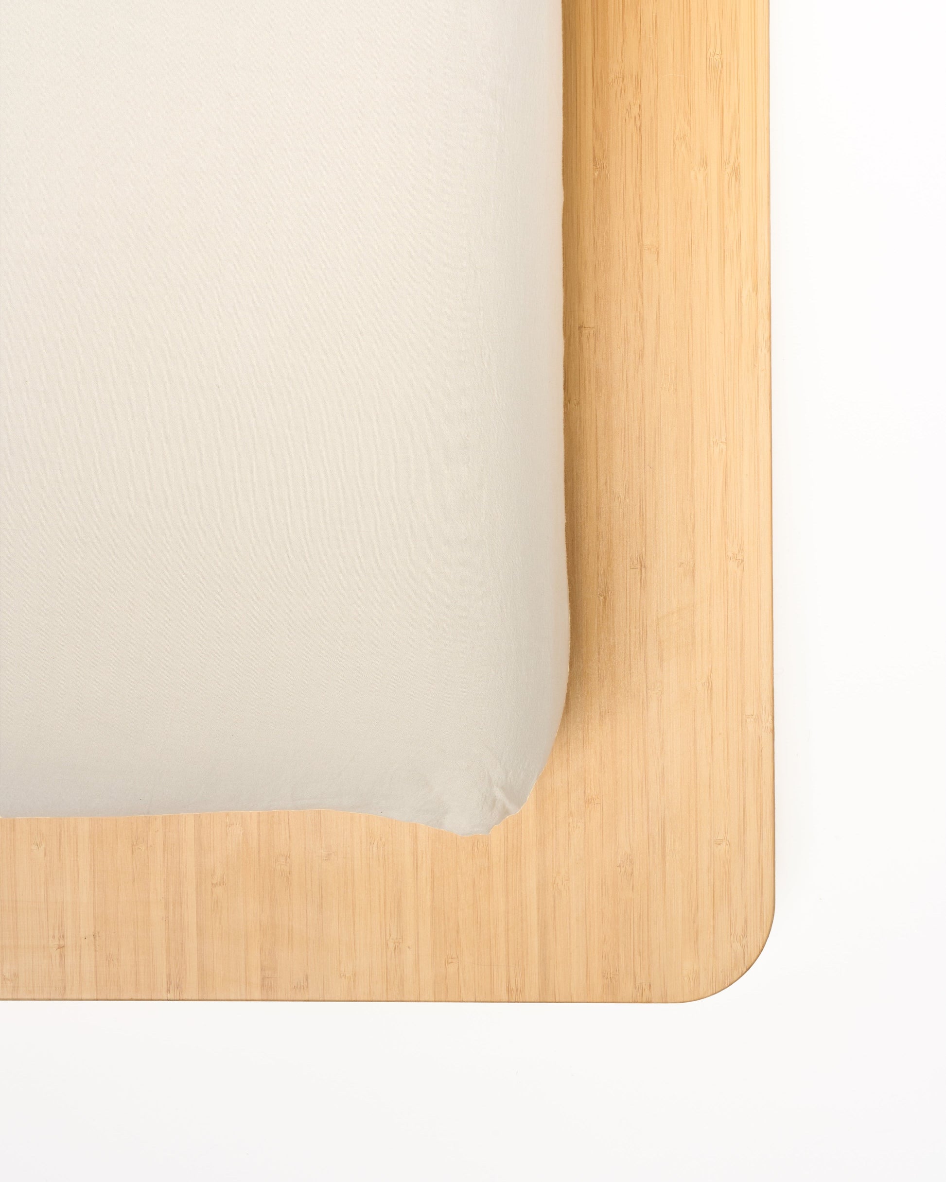 Signature Milk Fibre Sheet Set in Cream fitted sheet on natural wood bed frame corner detail
