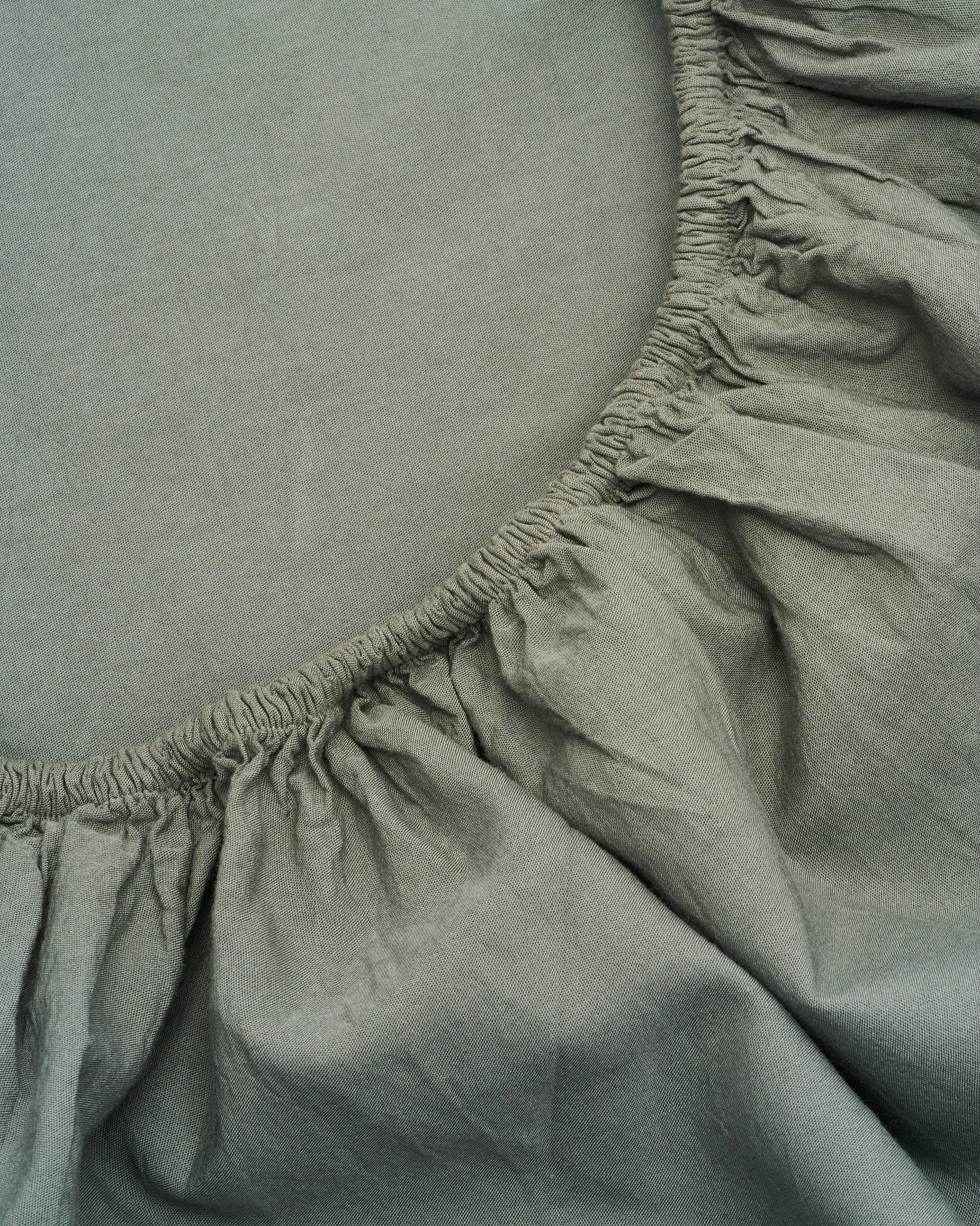 Signature Milk Fibre Sheet Set in Highlands Green fitted sheet elastic corner close up detail