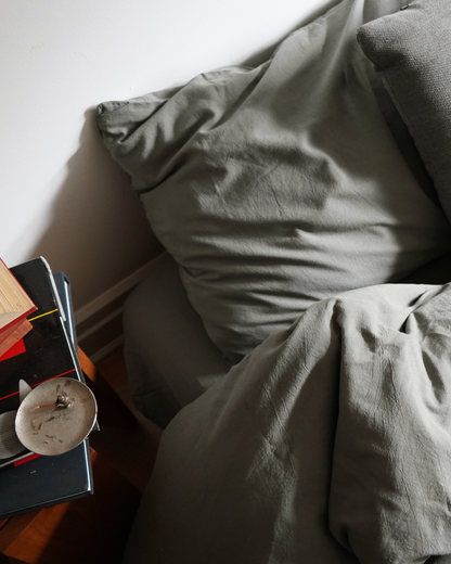 Signature Milk Fibre Sheet Set in Highlands Green pillow and sheet detail with nightstand books and decor