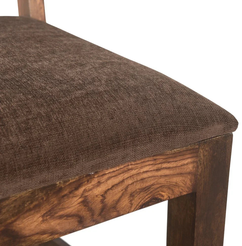 Close up detailed view highlighting the fabric texture of a brown upholstered seat cushion on a premium solid wood dining chair frame