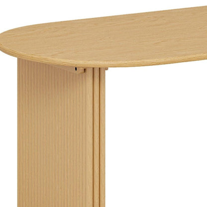 Close-up of oval tabletop edge and fluted pedestal base on solid wood double pedestal oval dining table in natural oak finish showing wood grain texture and ribbed panel construction
