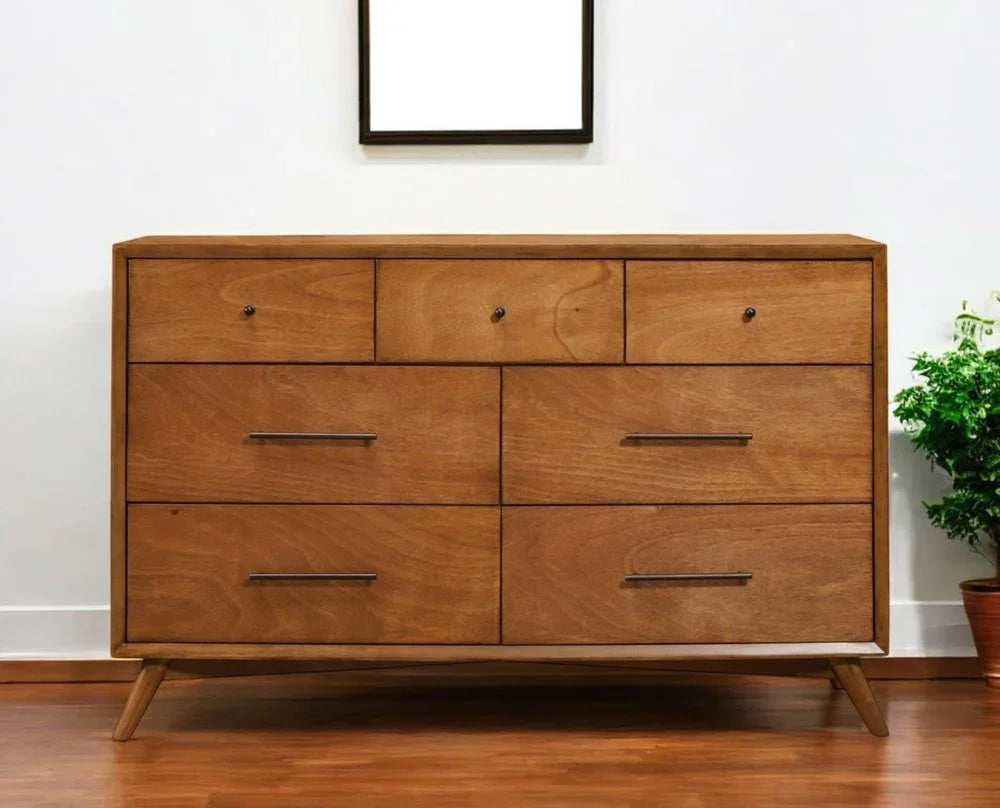 Solid mahogany seven-drawer double dresser front view styled with framed art and plant showing mixed hardware and splayed legs