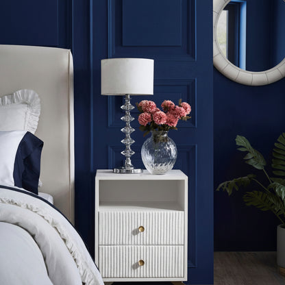 Stanford Fluted Two-Drawer Leather Nightstand white open shelf brass knobs crystal lamp pink flowers navy blue bedroom styled