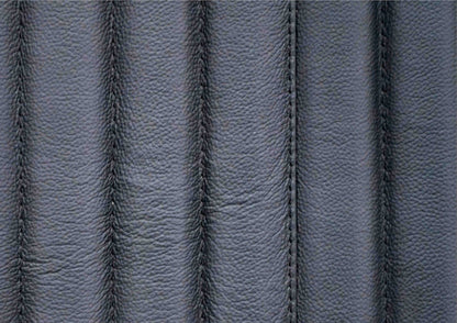 Macro close-up of genuine top grain black leather surface showing natural grain texture and vertical stripe quilting stitching detail with🌿