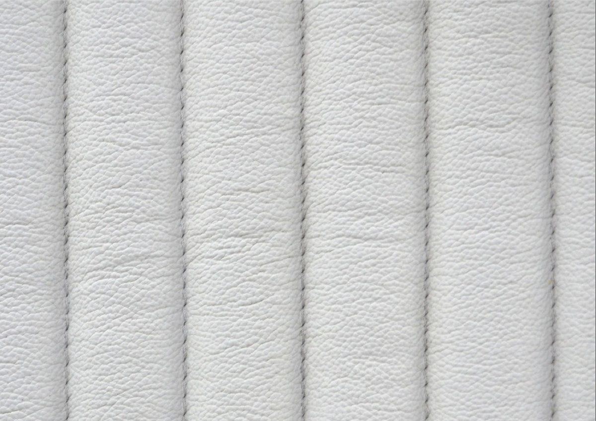 Close-up of genuine top grain white leather surface showing natural texture variations and vertical stripe quilting stitching detail. 🌿