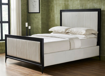 White genuine leather quilted bed frame with matte black border frame, vertical stripe quilting on panel headboard and footboard, iron legs, styled with white bedding and pillows in a modern bedroom with green textured walls and hardwood floor.