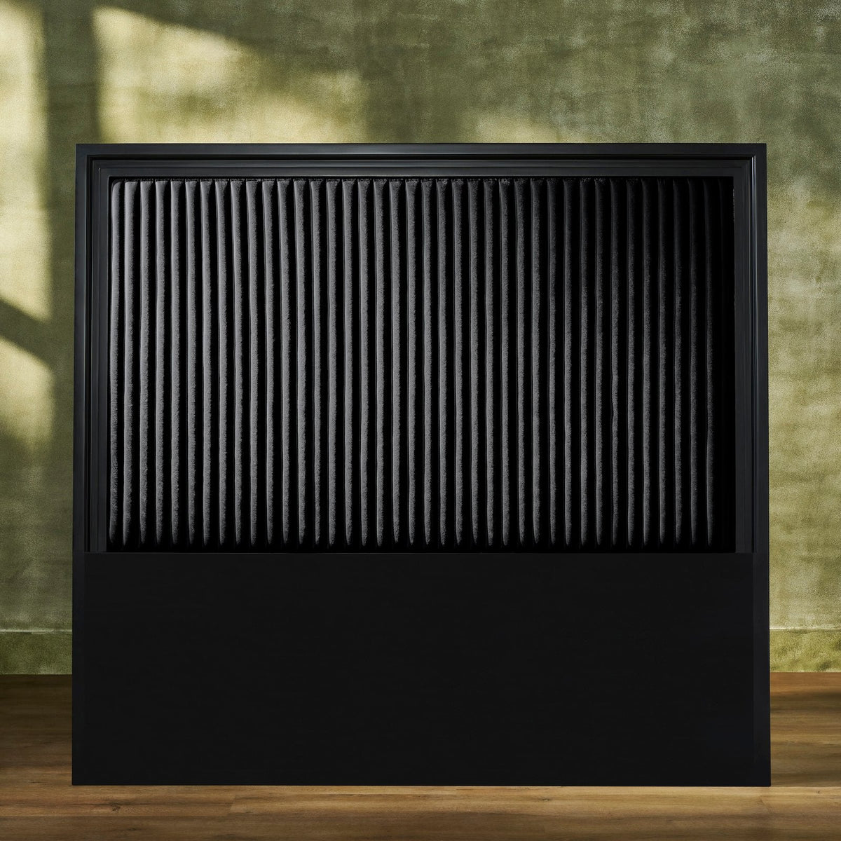 Stanford Genuine Leather Ribbed Headboard in all-black with matte frame and vertical ribbed leather panel styled against an earthy green wall