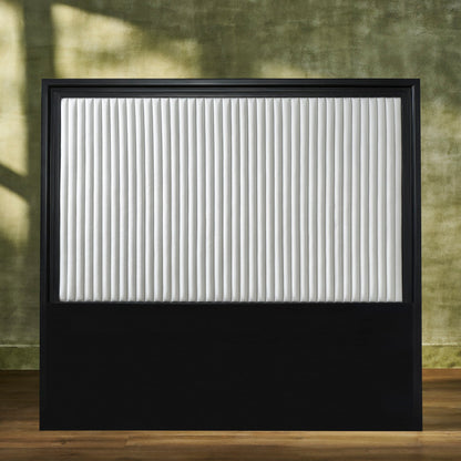 Stanford Genuine Leather Ribbed Headboard with black matte frame and white vertical ribbed leather panel styled against an earthy green wall