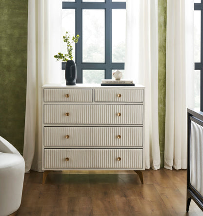 Stanford Ribbed Five-Drawer Leather Chest in white genuine leather styled with a dark ceramic vase and coffee table book against sage green walls and natural light