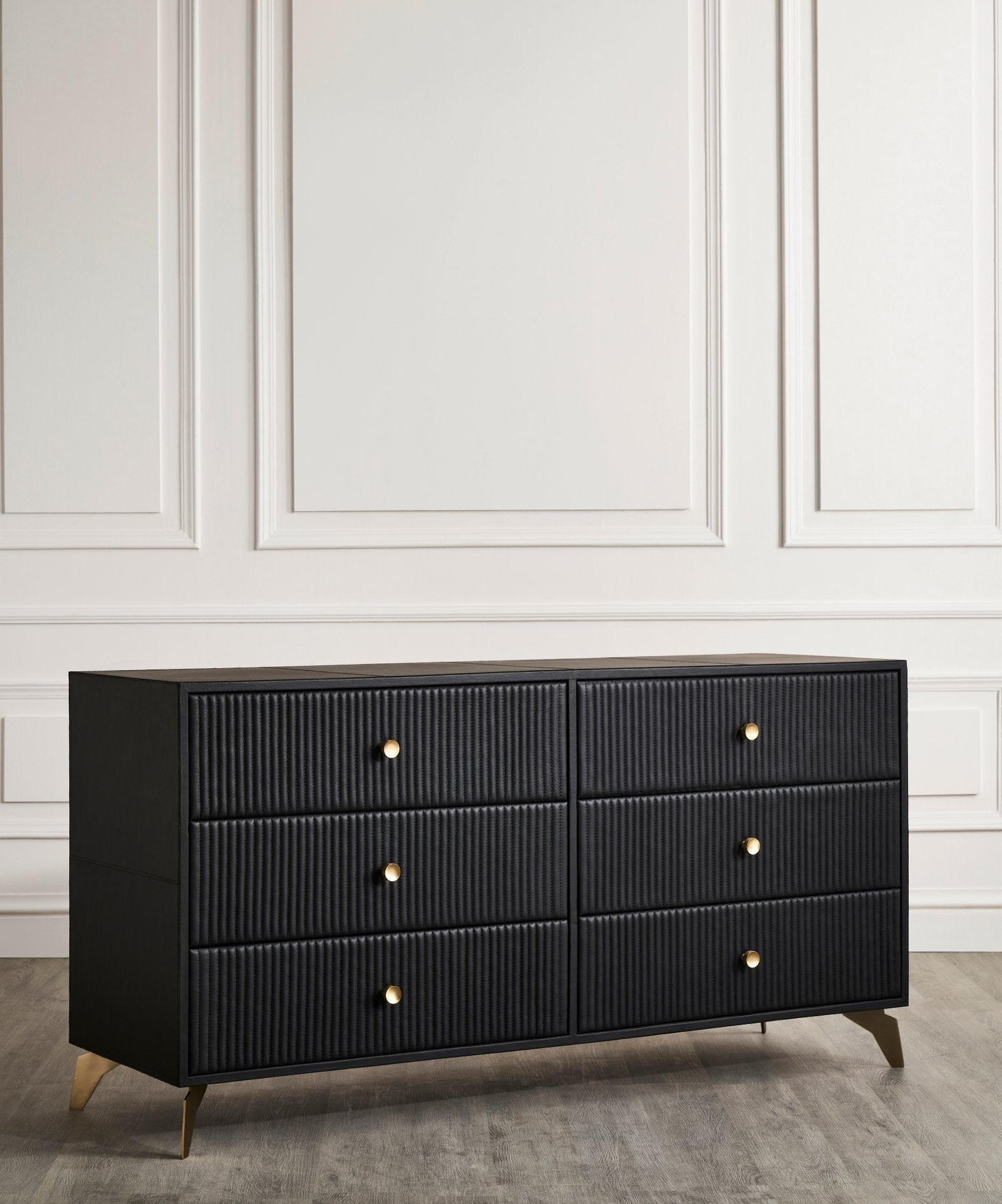Stanford Ribbed Six-Drawer Leather Dresser black six drawers brass knobs brass-finished legs front view white paneled wall