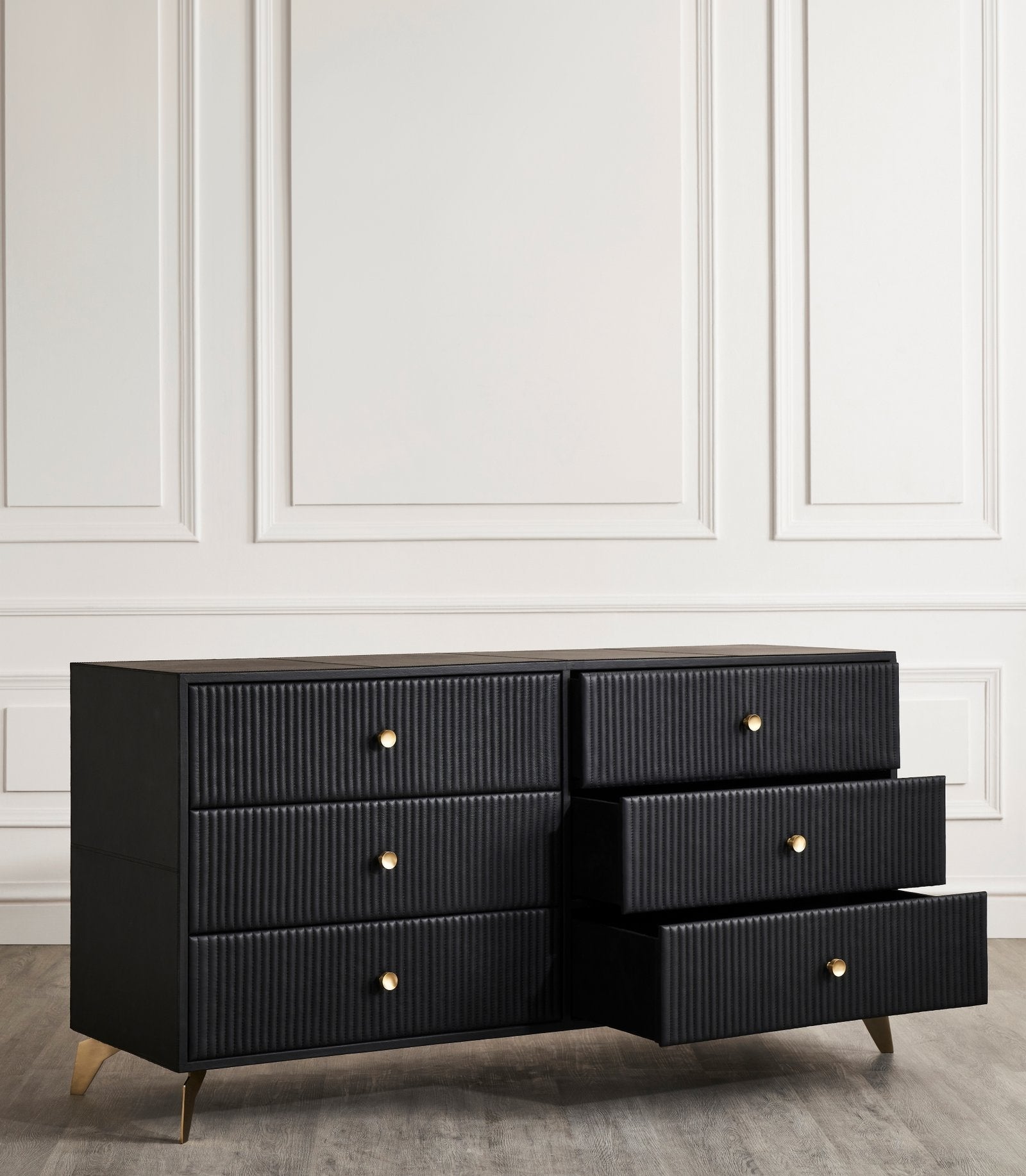 Stanford Ribbed Six-Drawer Leather Dresser black three drawers open brass knobs brass-finished legs white paneled wall
