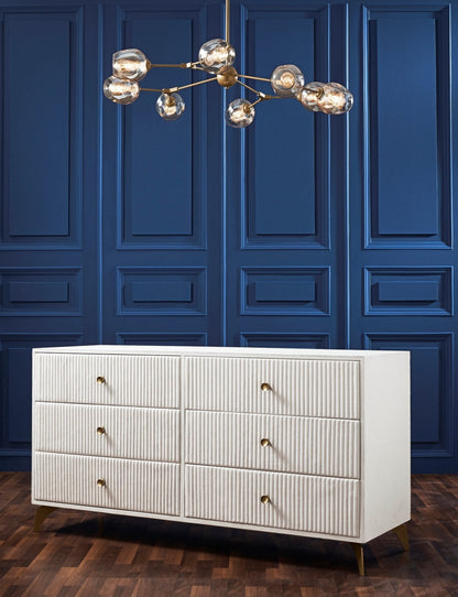 Stanford Ribbed Six-Drawer Leather Dresser white six drawers brass knobs brass-finished legs styled bedroom navy blue paneled wall brass chandelier hardwood floor