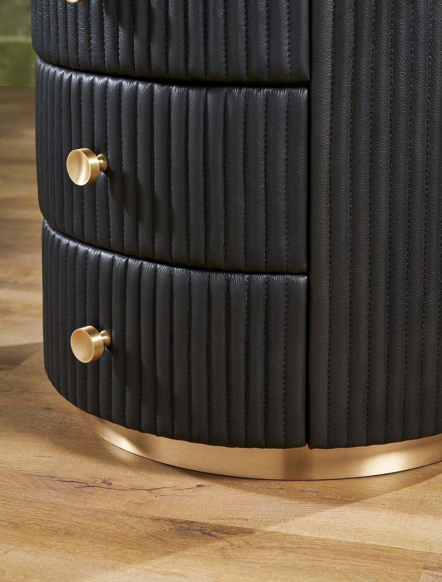 Stanford Round Fluted Leather Nightstand black brass knobs brass rim base drawers close up detail hardwood floor