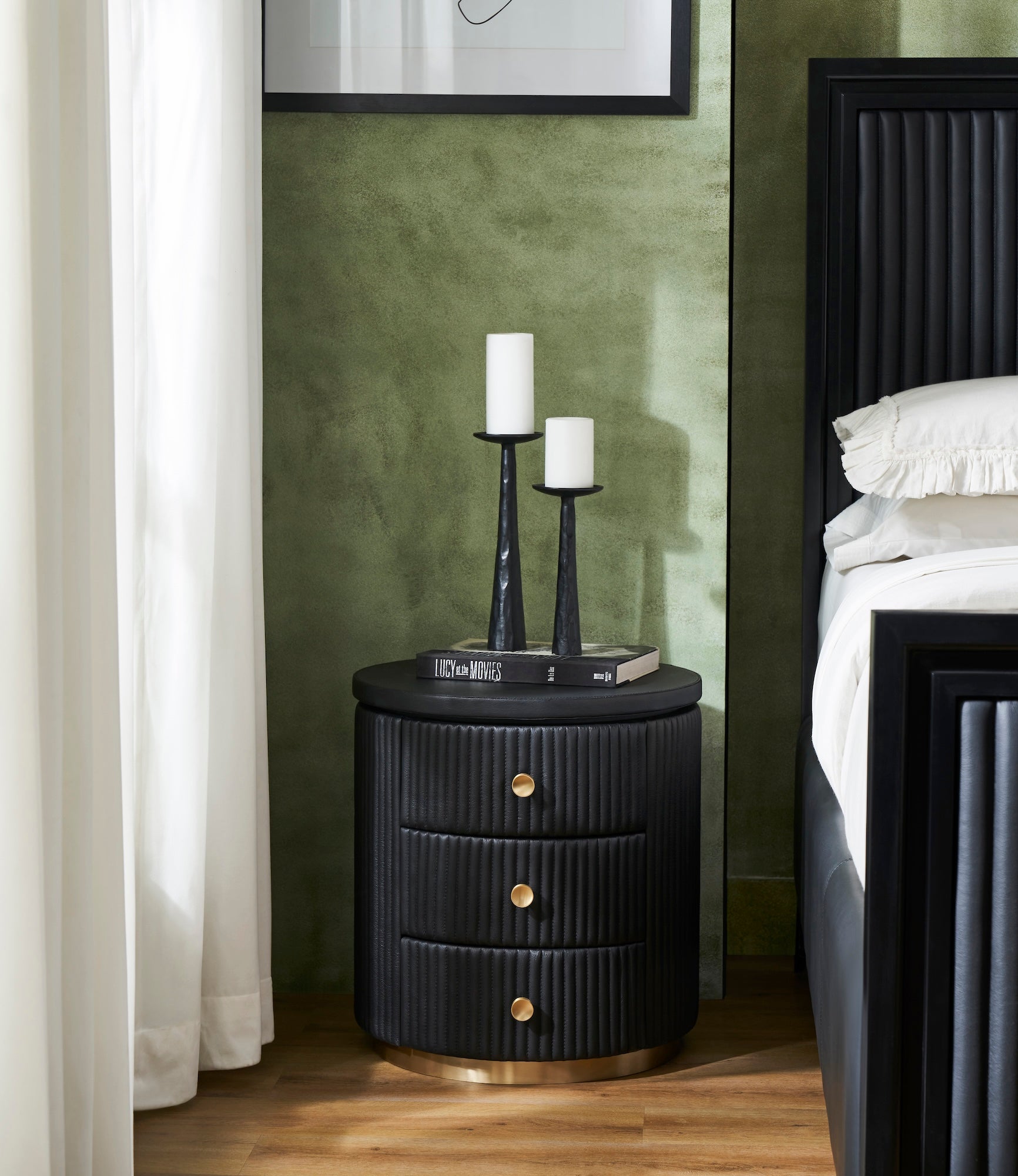 Stanford Round Fluted Leather Nightstand black candle holders books styled green bedroom beside fluted bed brass rim base side view